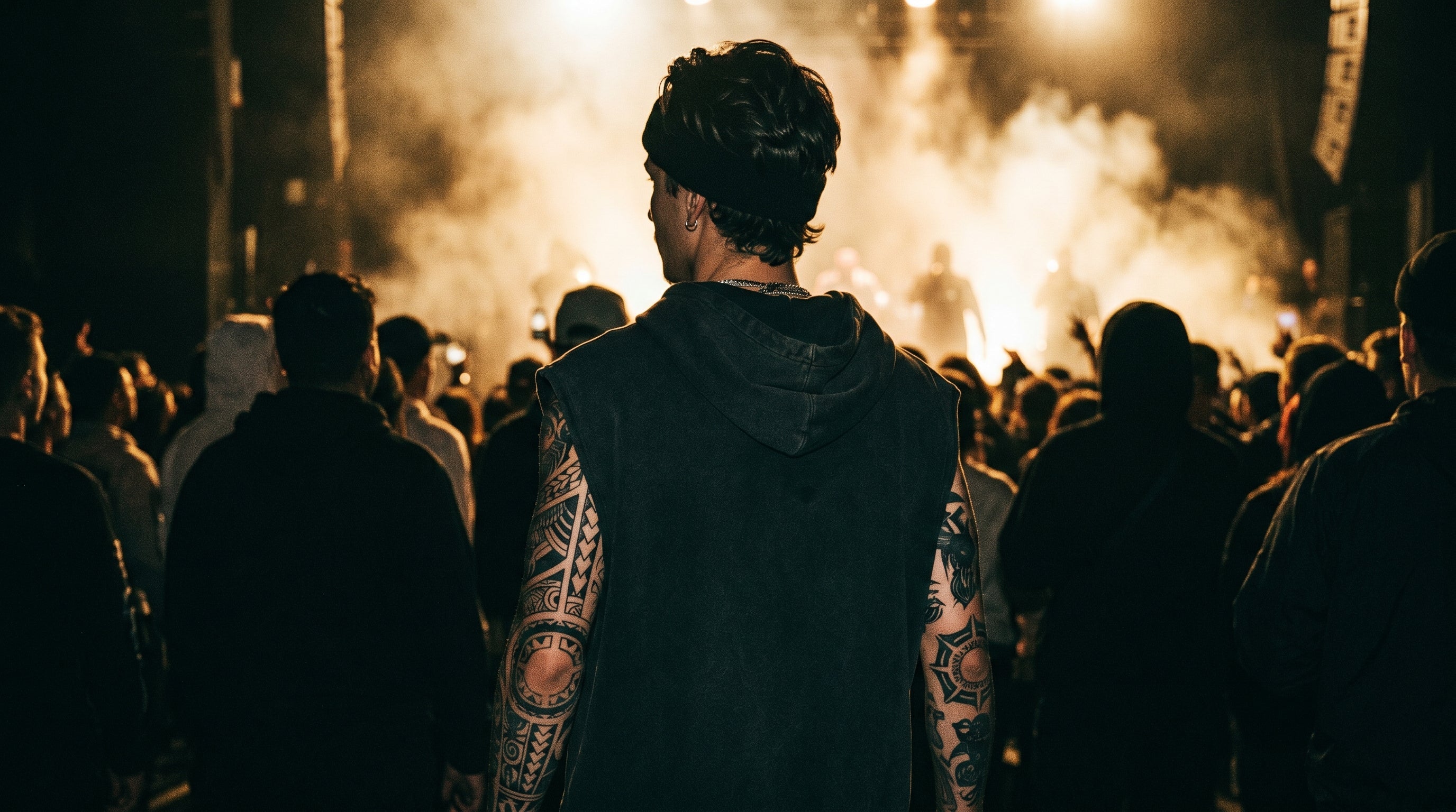 Tatouage Travis Scott : ambiance concert dark avec bras tatoués tribaux